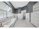 Elegant bathroom with a soaking tub, white cabinetry, and marble tile flooring at 1064 Harbour Way Pl, Punta Gorda, FL 33983