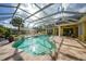 Screened pool area with safety railing, hot tub, pavers, and some landscaping at 1064 Harbour Way Pl, Punta Gorda, FL 33983