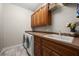 Laundry room with wood cabinets, washer, dryer, and utility sink at 1422 Kittiwake Dr, Punta Gorda, FL 33950