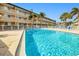 Community pool with lounge chairs and tropical landscaping at 150 Harborside Ave # 313, Punta Gorda, FL 33950