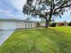 Charming single-story home with attached garage, lush lawn, and mature trees at 1626 Sharpe St, Port Charlotte, FL 33952