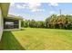 Large backyard with grassy lawn and screened patio at 18854 Ackerman Ave, Port Charlotte, FL 33948