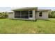 Back exterior view showing a screened patio and lawn at 18854 Ackerman Ave, Port Charlotte, FL 33948