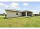 Back exterior view showing a screened patio and lawn at 18854 Ackerman Ave, Port Charlotte, FL 33948