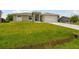 Landscaped front yard with a large grassy area at 18854 Ackerman Ave, Port Charlotte, FL 33948