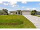 Newly built home with a tan exterior and a driveway at 18854 Ackerman Ave, Port Charlotte, FL 33948