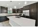 Modern kitchen with dark cabinetry, stainless steel appliances, and quartz countertops at 18854 Ackerman Ave, Port Charlotte, FL 33948