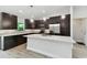 Modern kitchen featuring a large island, stainless steel appliances, and dark cabinetry at 18854 Ackerman Ave, Port Charlotte, FL 33948