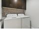 Laundry room with washer, dryer, and hexagon tile at 18854 Ackerman Ave, Port Charlotte, FL 33948