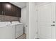Laundry room with washer, dryer, and dark brown cabinets at 18854 Ackerman Ave, Port Charlotte, FL 33948