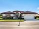 Attractive single-story home with tile roof, attached garage, and landscaped front yard at 1946 Cove Pointe Dr, Venice, FL 34293