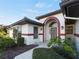 Attractive front yard with landscaped beds and a tiled walkway to the entrance at 1946 Cove Pointe Dr, Venice, FL 34293