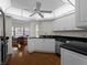 Kitchen with white cabinetry, dark countertops, breakfast nook, and wood floors at 1946 Cove Pointe Dr, Venice, FL 34293