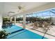 Spacious screened patio with fire pit, ample seating, and pool views at 1946 Cove Pointe Dr, Venice, FL 34293