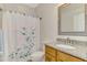 Guest bathroom with granite countertop and floral shower curtain at 2459 Sherman Oak Dr, North Port, FL 34289