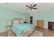 Primary bedroom with teal walls, wood floors, and ensuite bathroom at 2459 Sherman Oak Dr, North Port, FL 34289