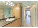 Bathroom with single vanity, decorative wallpaper, and access to hallway at 3340 Wood Thrush Dr # 323, Punta Gorda, FL 33950