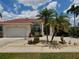 Inviting home featuring a terracotta roof, elegant columns, and lush tropical landscaping at 3730 Whippoorwill Blvd, Punta Gorda, FL 33950