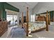 Spacious main bedroom with a four-poster bed, elegant decor, and seamless access to the outdoor patio at 3730 Whippoorwill Blvd, Punta Gorda, FL 33950