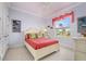 Pastel bedroom with decorative fish accents, a comfortable bed, and a bright view of the outdoors from a large window at 4431 Gardner Dr, Port Charlotte, FL 33952