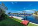 Boat dock featuring a boat on a lift, and lush green lawn at 4431 Gardner Dr, Port Charlotte, FL 33952