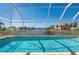 Backyard pool area enclosed by a screen offers a refreshing view of the waterway and tropical landscaping at 4431 Gardner Dr, Port Charlotte, FL 33952