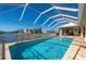 A sparkling pool enclosed in a screened lanai, with views of the waterfront at 4431 Gardner Dr, Port Charlotte, FL 33952