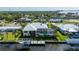Back of waterfront home featuring a screened-in pool, boat dock, and well-maintained lawn with palm trees at 4431 Gardner Dr, Port Charlotte, FL 33952