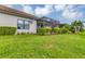 Home with a screened patio, lush lawn, and manicured hedges at 11137 Mcdermott Ct, Englewood, FL 34223