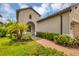 Brick pathway leads to the front entrance of the house, surrounded by lush greenery at 11137 Mcdermott Ct, Englewood, FL 34223