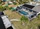 Aerial view of canal-side home featuring a screened pool and private dock at 18345 Ohara Dr, Port Charlotte, FL 33948