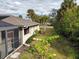 View of home's backyard, showing a screened enclosure and landscaping at 18345 Ohara Dr, Port Charlotte, FL 33948