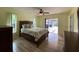 Bedroom with wood flooring, ceiling fan, and sliding glass doors to patio at 18345 Ohara Dr, Port Charlotte, FL 33948