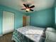 Bedroom with ceiling fan, double closet, and light teal walls at 18345 Ohara Dr, Port Charlotte, FL 33948