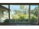 Relaxing backyard view framed by a large window, showcasing lush landscaping and neighboring houses at 18345 Ohara Dr, Port Charlotte, FL 33948