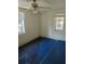 Small bedroom with window, ceiling fan and damaged flooring at 205 Chasteen St, Punta Gorda, FL 33950