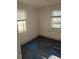 Small bedroom with two windows and damaged flooring at 205 Chasteen St, Punta Gorda, FL 33950