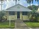 Cute yellow house with a metal roof, landscaping, and walkway at 205 Chasteen St, Punta Gorda, FL 33950