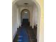 Long hallway with arched doorways and damaged flooring at 205 Chasteen St, Punta Gorda, FL 33950