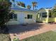 Brick paved patio with two chairs and a table in front of a yellow house at 205 Chasteen St, Punta Gorda, FL 33950