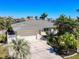 This beautifully landscaped home features a two-car garage and a well-manicured front yard with mature palms at 210 Divinci Dr, Punta Gorda, FL 33950