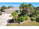 Beautiful single-story waterfront home surrounded by tropical landscaping and mature palm trees at 210 Divinci Dr, Punta Gorda, FL 33950