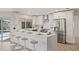 Modern kitchen features white cabinetry, stainless steel appliances, and a spacious island with bar stool seating at 210 Divinci Dr, Punta Gorda, FL 33950