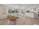 Bright living area features an open kitchen, natural light, and wood-look tile floors, perfect for entertaining at 210 Divinci Dr, Punta Gorda, FL 33950
