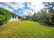 Landscaped backyard with lush grass and mature trees at 2137 Adirondack Ln, Port Charlotte, FL 33953