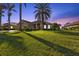 Charming single-story home featuring a spacious lawn and lush tropical landscaping at twilight at 2895 Mill Creek Rd, Port Charlotte, FL 33953