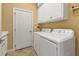 Bright laundry room with washer, dryer, and ample cabinet space at 2895 Mill Creek Rd, Port Charlotte, FL 33953