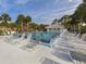 Community pool area with numerous lounge chairs at 437 Cerromar Ln # 312, Venice, FL 34293