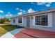 Newly painted house exterior with gray walls, red brick patio, and a gray front door at 5032 Koli Ct, North Port, FL 34287