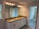 Bathroom with double vanity, granite countertops, white cabinets, large mirror, and modern lighting fixtures at 9506 Melody Cir, Port Charlotte, FL 33981
